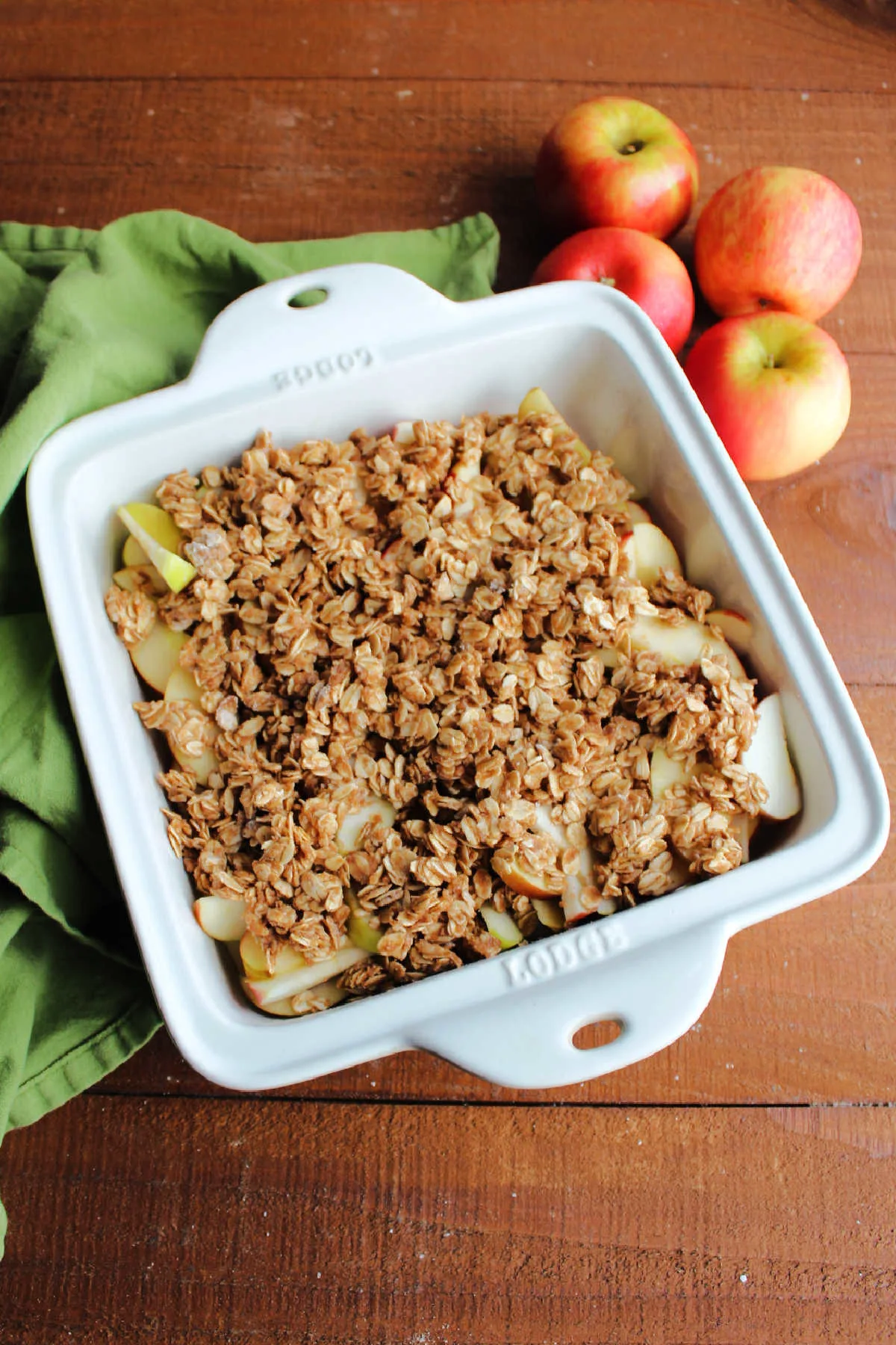 Square baking dish filled with fresh baked apple crisp with golden oat crumbles on top.