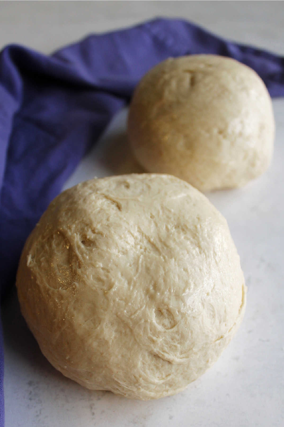Two balls of sourdough pizza crust, ready to be made into pizzas.
