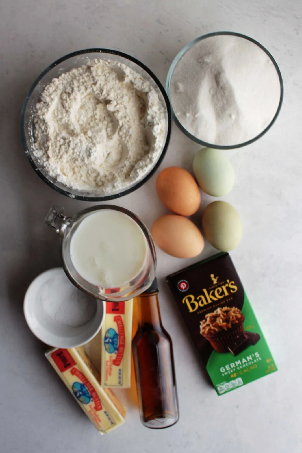 Ingredients including German chocolate, butter, vanilla, buttermilk, eggs, flour, sugar, salt and baking soda ready to be made into German chocolate cake batter.