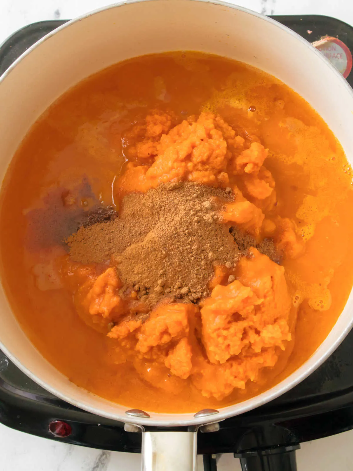 pumpkin puree, apple juice and spices in saucepan ready to be made into pumpkin butter.