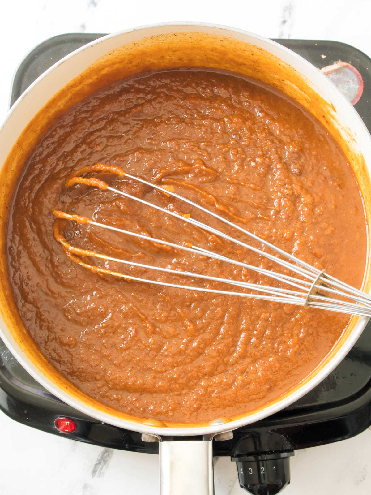 Sugar, spices, apple juice and pumpkin puree whisked together in saucepan.