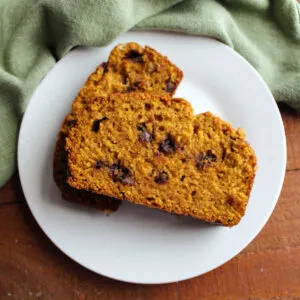 Slices of chocolate chip pumpkin bread on small white plate.