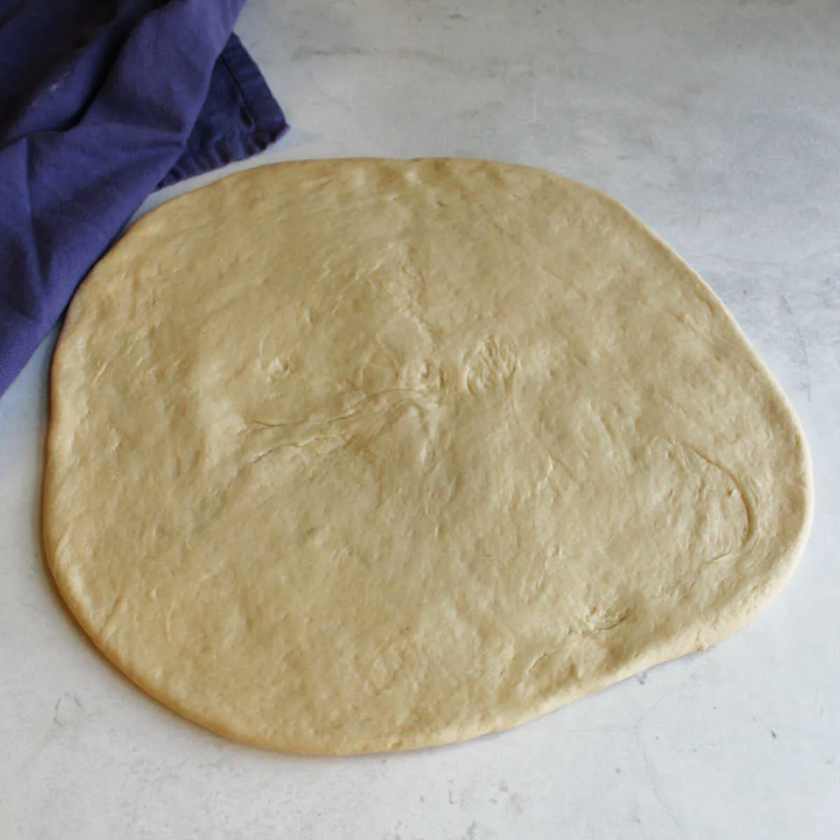 Circle of sourdough pizza dough ready to be topped and cooked.