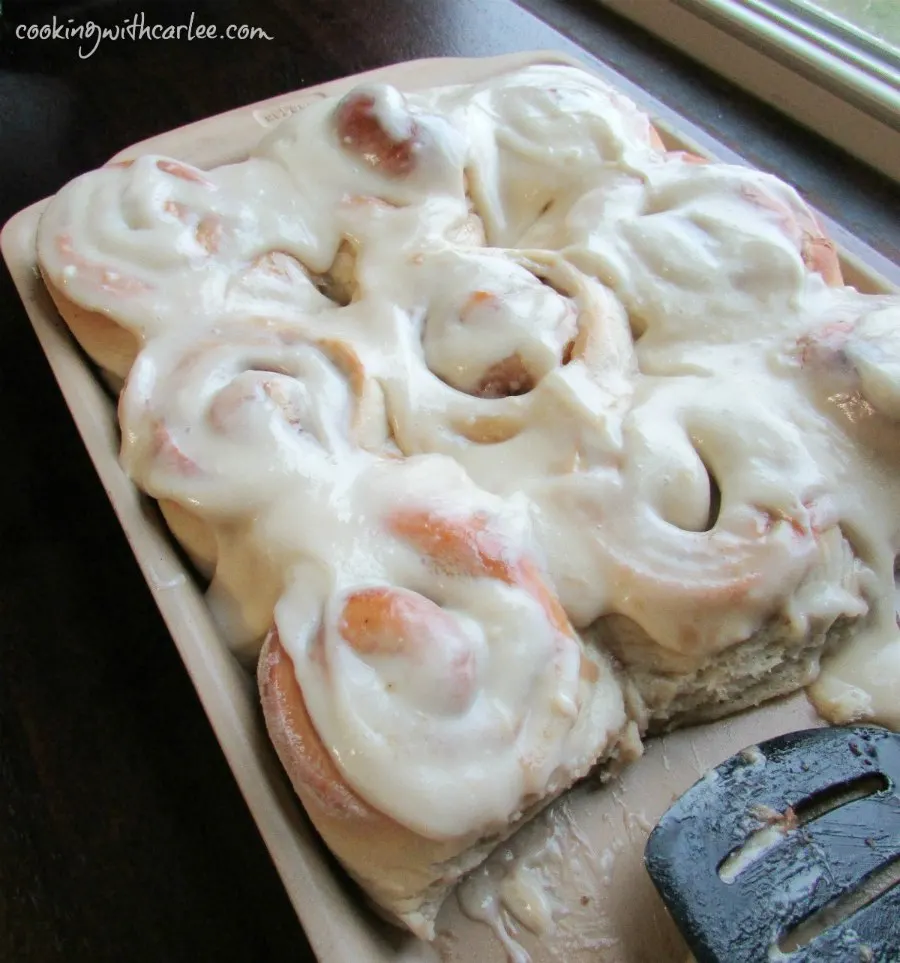 tray of cinnamon buns with plenty of cream cheese frosting.