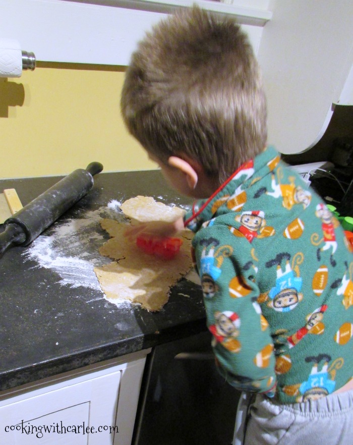 Little Dude cutting out oatmeal cookie dough with cookie cutters. 