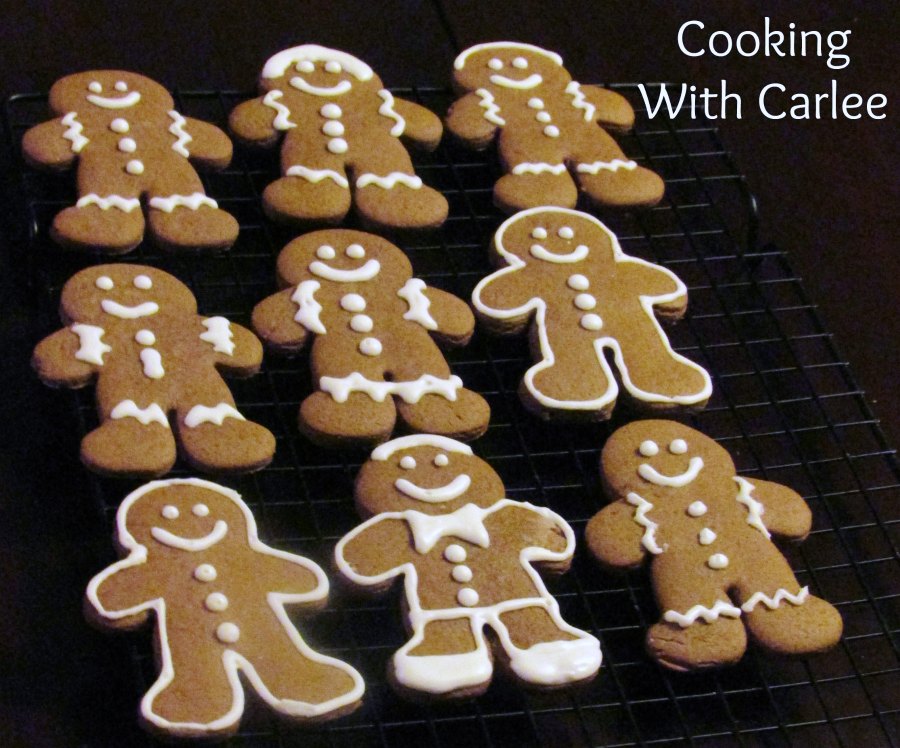German gingerbread cookie men decorated with white royal icing on cooling rack.
