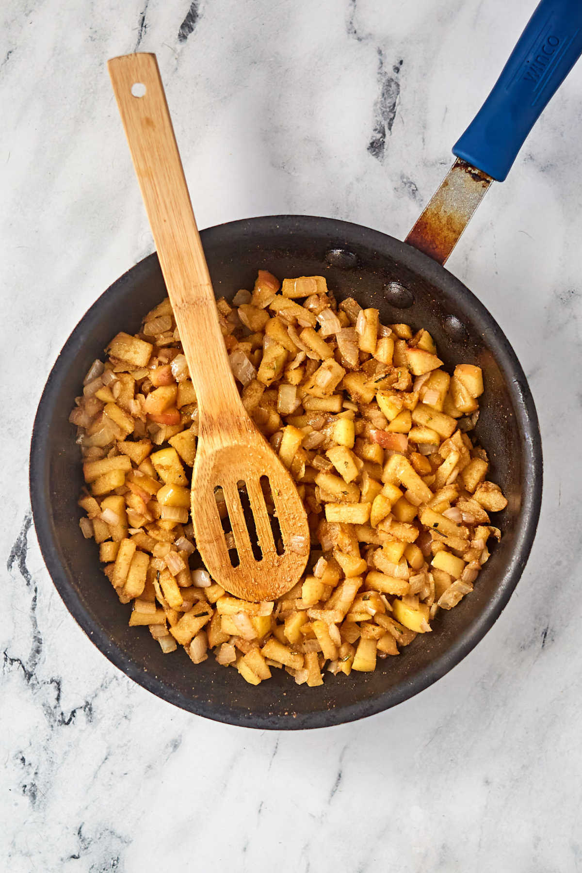 Skillet with cooked apple mixture, browned from being cooked and the balsamic vinegar inside.