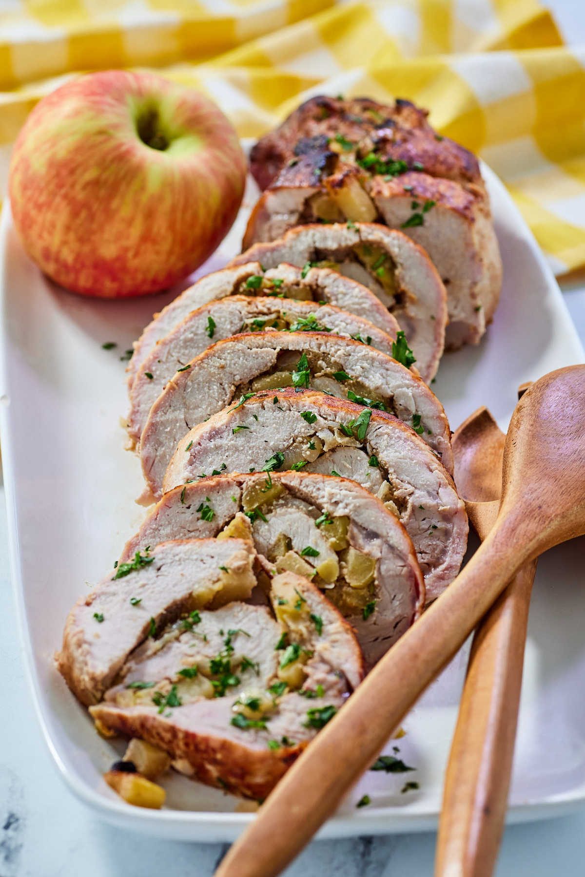 Platter of pork loin stuffed with apples on platter, ready to eat. 