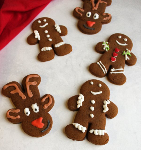 decorated gingerbread cookies in shapes of gingerbread men and reindeer.