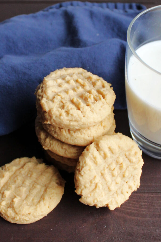 stack of classic peanut butter cookies next to glass of milk