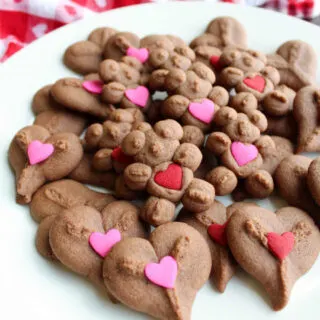 plate of chocolate spritz hearts and bears with pink and red heart decorations on them