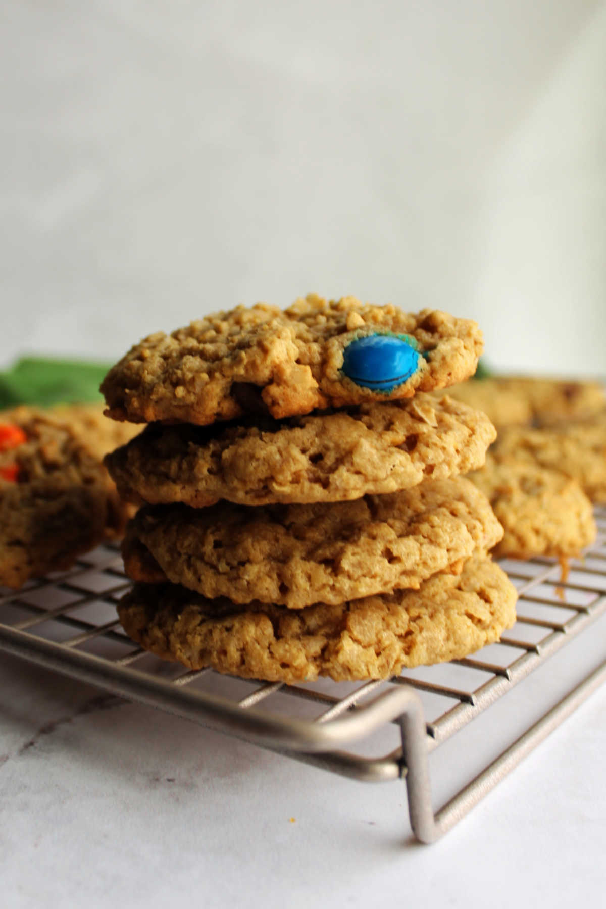 Stack of fresh monster cookies on cooling rack.