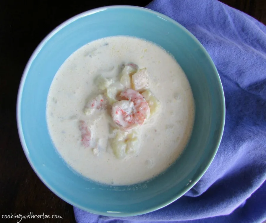 Bowl of creamy seafood chowder with a couple of shrimp on top.