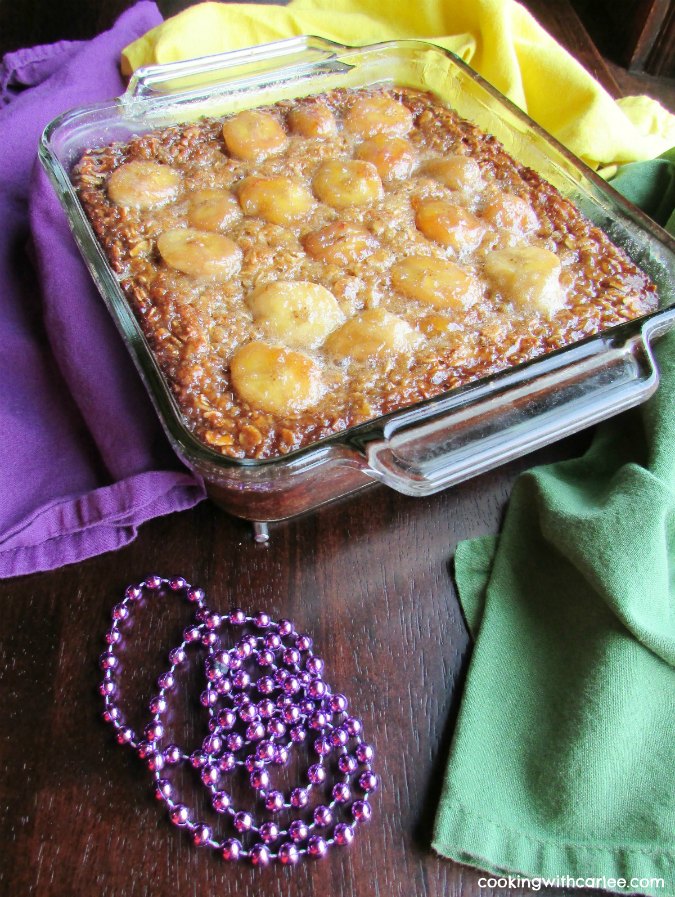 pan of bananas foster baked oatmeal fresh from the oven surrounded by beads and Mardis Gras colors