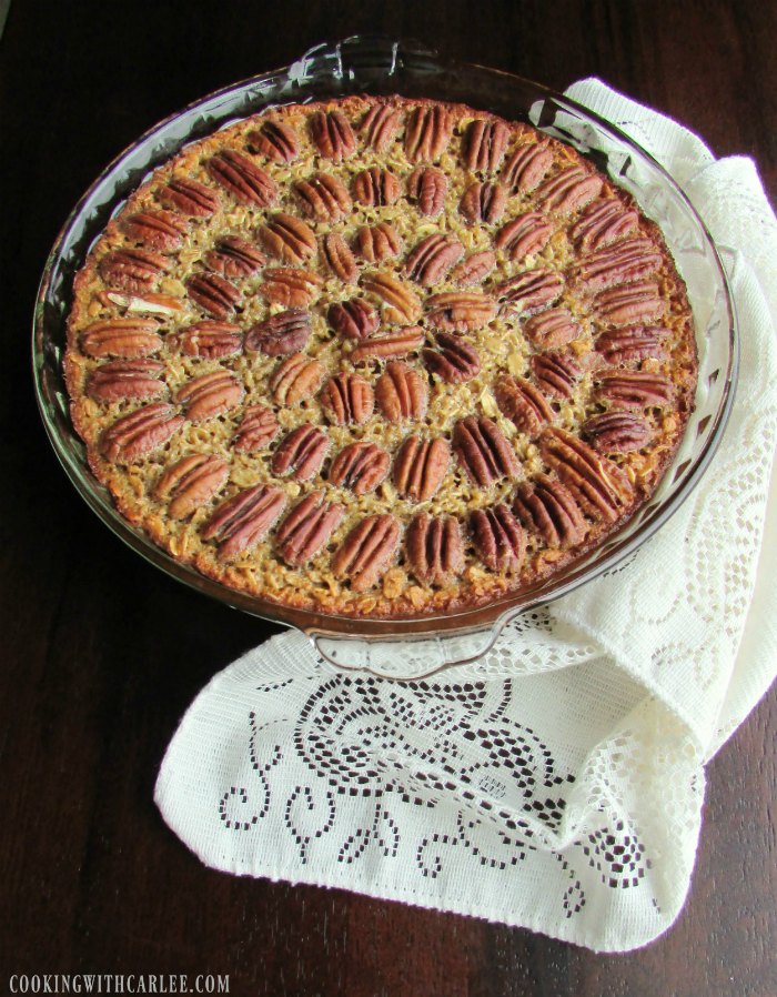 pan of pecan pie baked oatmeal with whole pecans arranged in circles over the top.