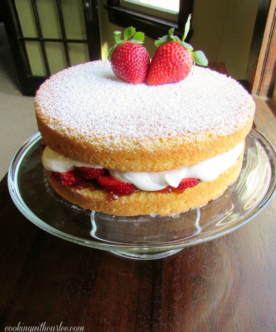 whole victoria sponge cake with strawberries and whipped cream filling