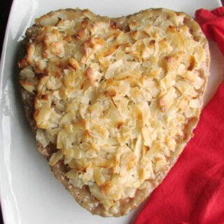Heart shaped cake topped with golden flaked coconut and soaked in syrup.