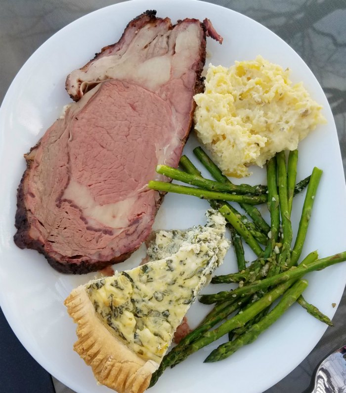 slice of pie on plate with prime rib, asparagus and potatoes