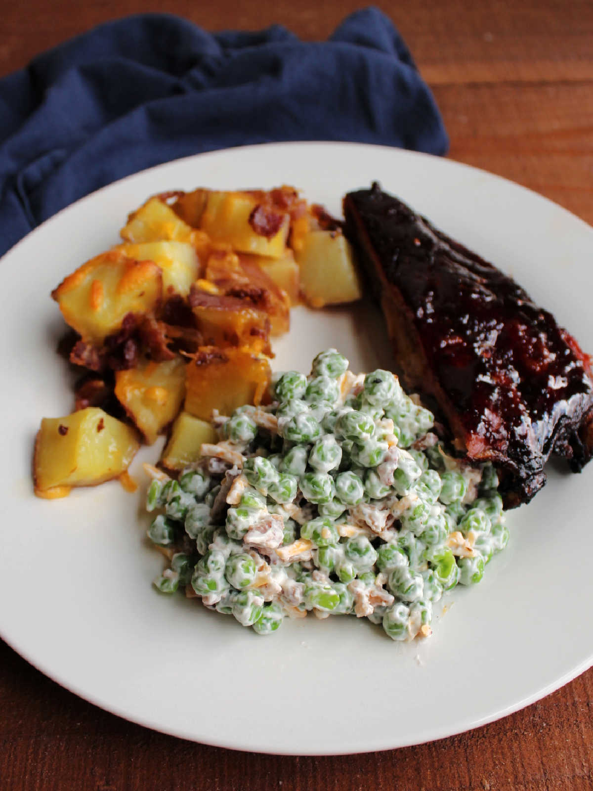 Pea salad served with BBQ ribs and cheesy potatoes with bacon.