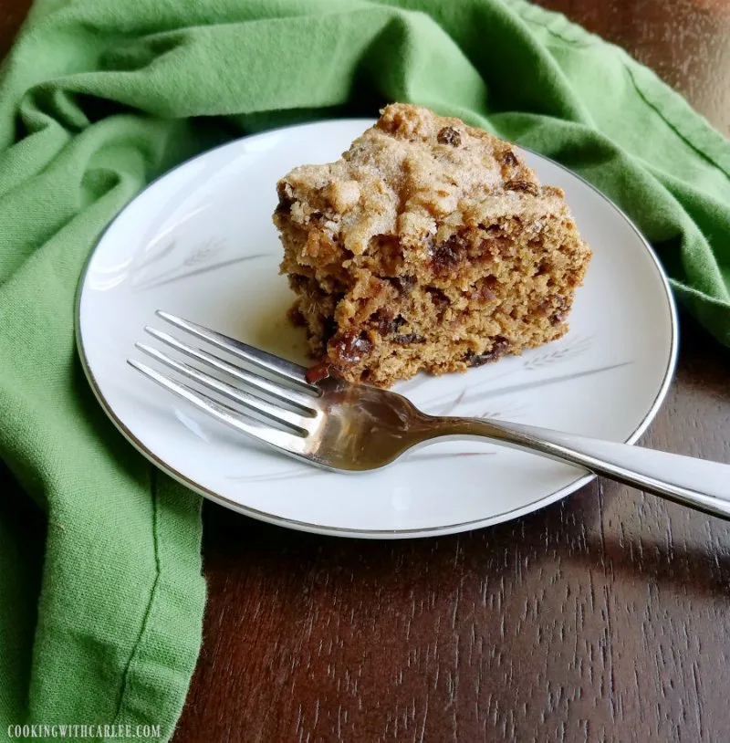 slice of tea brack cake with raisins and dates on plate with fork, bite missing.