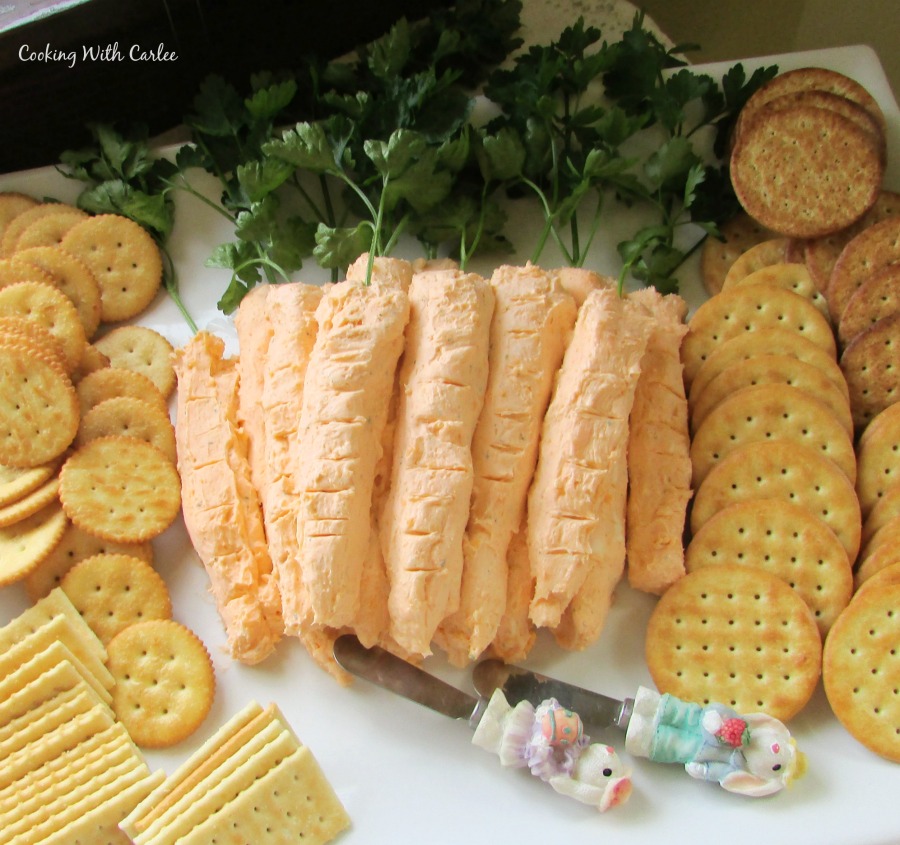 platter of carrot shaped cheese balls with easter bunny spreader knives and crackers.