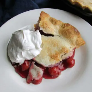 slice of tart cherry pie served with whipped cream.