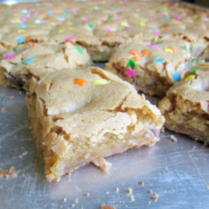 squares of sprinkle topped blondies on baking tray.