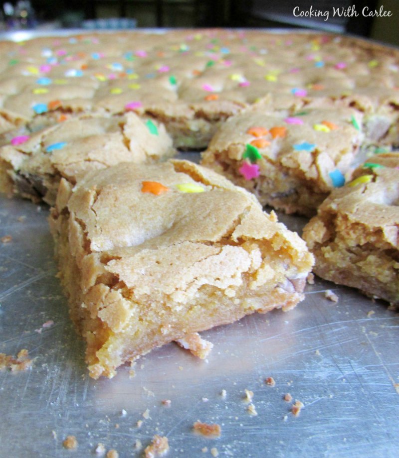 squares of sprinkle topped blondies on baking tray.