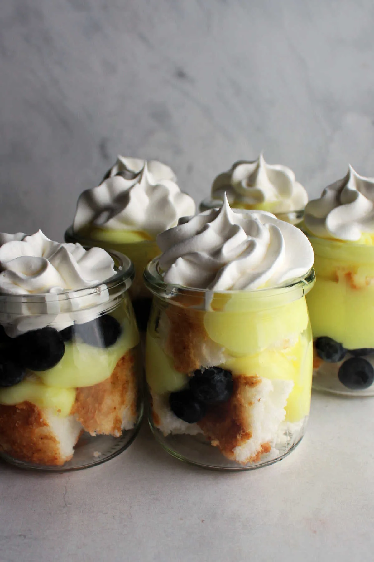 Jars filled with lemon, blueberry and angel food cake trifle. 