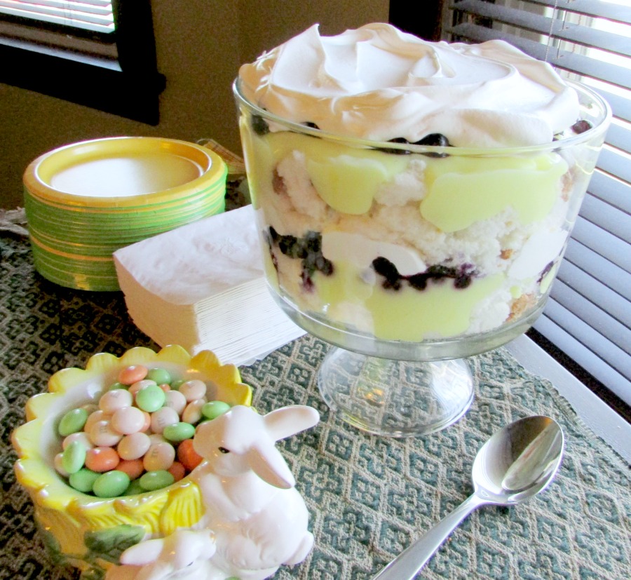 trifle bowl filled with layers of lemon goodness, angel food cake and blueberries topped with whipped cream.