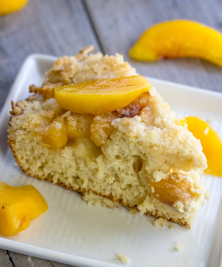 Slice of peach breakfast cake served with peach slices