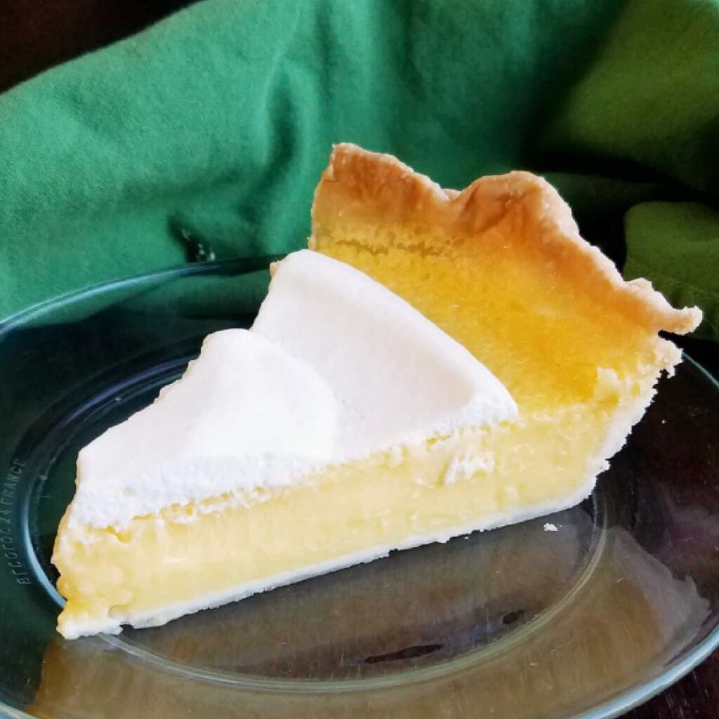 slice of lemon pie topped with a layer of honey whipped cream