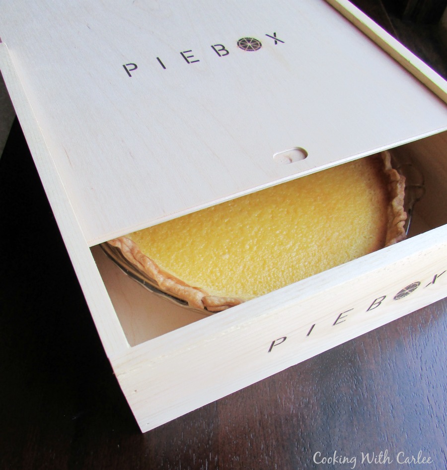pie box partially open with lemon pie inside.