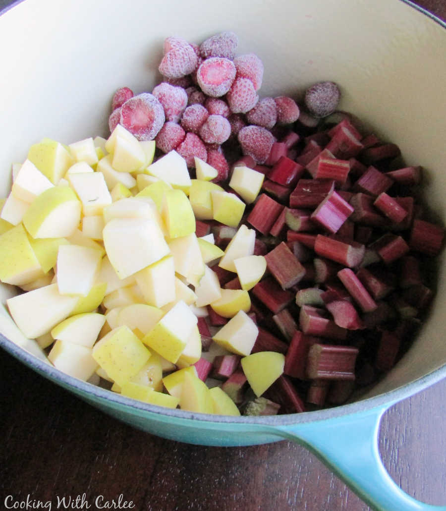 pot full of chopped apples and rhubarb and frozen strawberries.