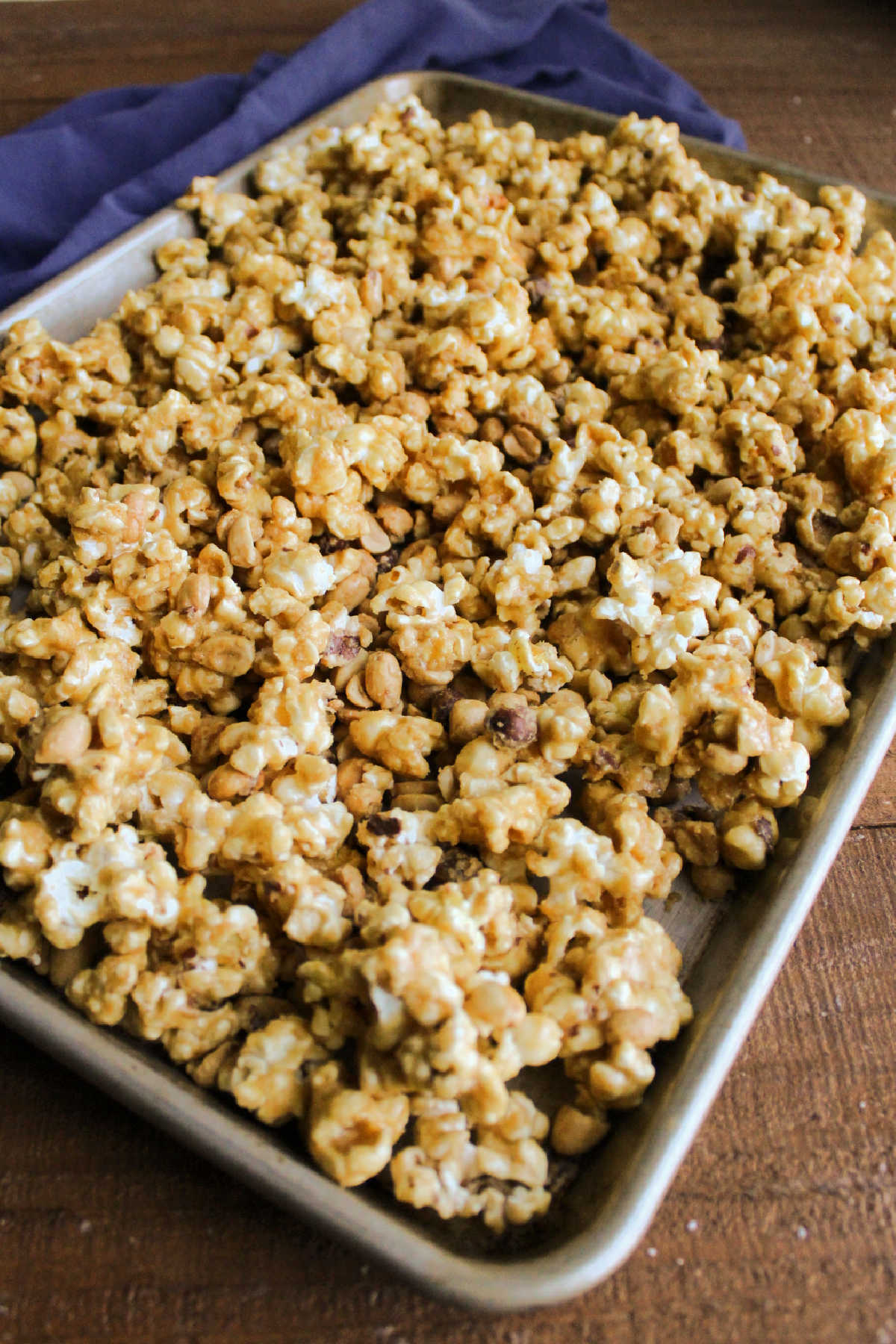 Sheet pan filled with baked caramel corn fresh from the oven, showing crispy texture of caramel.