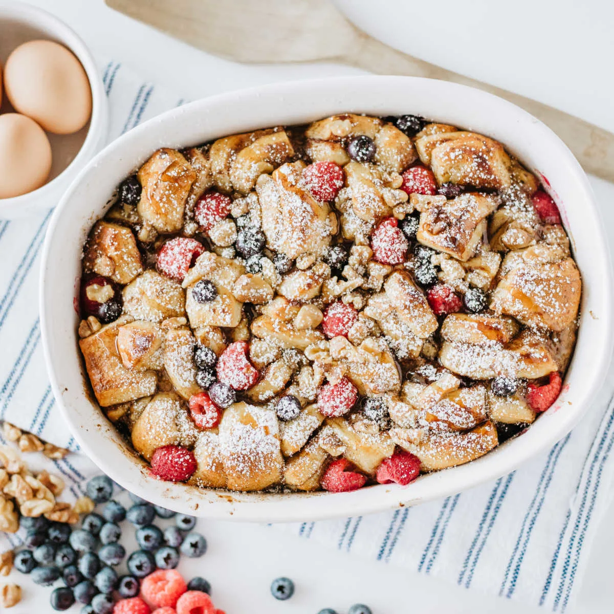 Casserole dish filled with cinnamon roll and berry french toast bake, ready to be served.