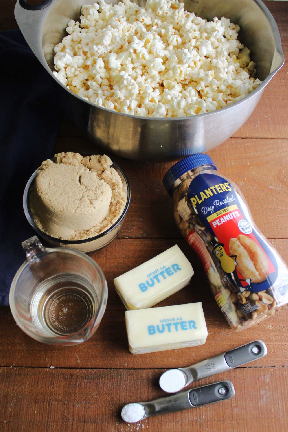 Ingredients including popped popcorn, brown sugar, corn syrup, butter, salt, baking soda, and peanuts. 