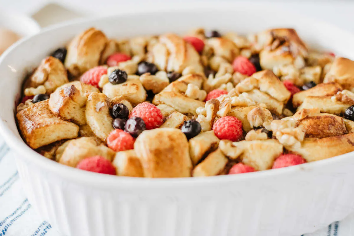 Baked cinnamon roll french toast casserole with berries.