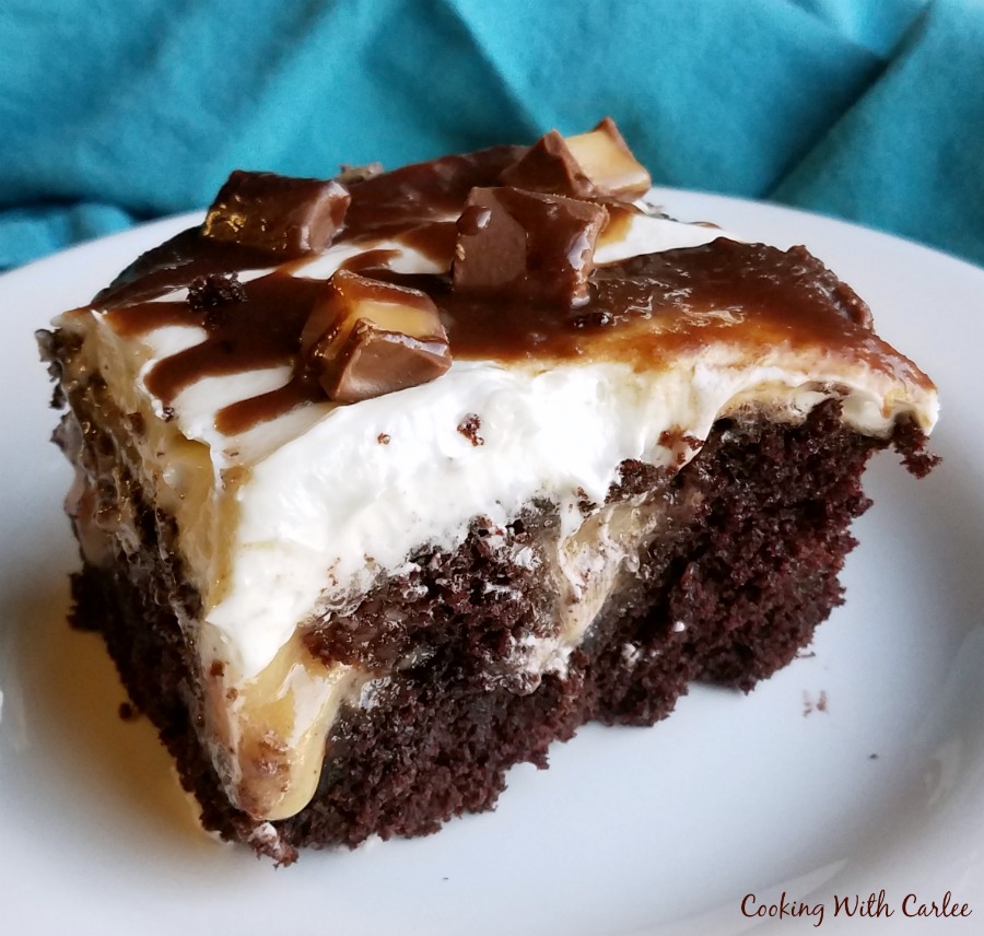 piece of chocolate cake with gooey caramel inside and white frosting on top.