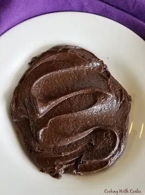 fudge frosting smoothed out over plate to show consistency