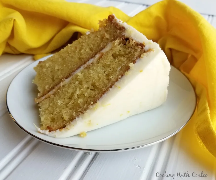 slice of layered lemon velvet cake with creamy lemon buttercream on outside.
