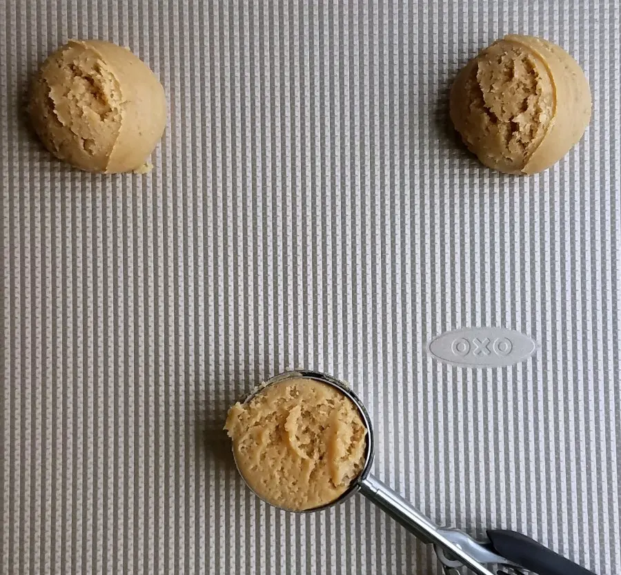 scoops of maple cinnamon cookie dough on cookie sheet getting ready to bake.