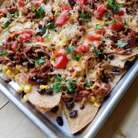 Loaded BBQ Pulled Pork Nachos 4 sheet pan loaded up with bbq pulled pork nachos and tons of fun toppings.
