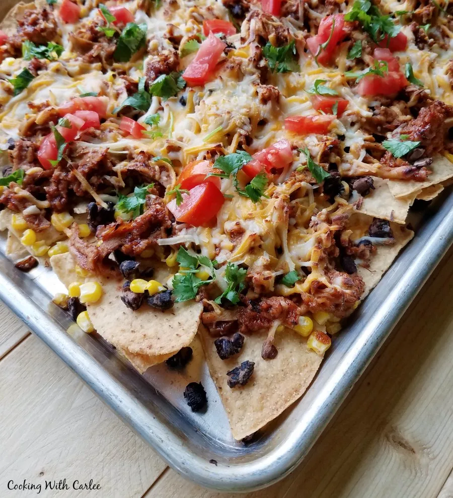 Sheet pan filled with tortilla chips, pulled pork, cheese etc.