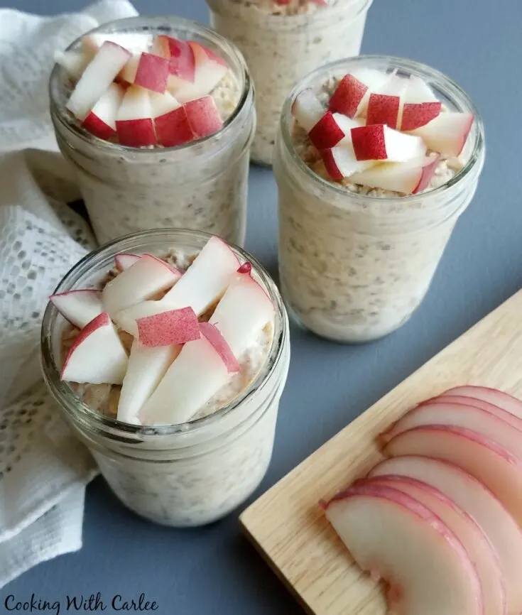 sliced white peaches next to jars of overnight oatmeal topped with fruit.
