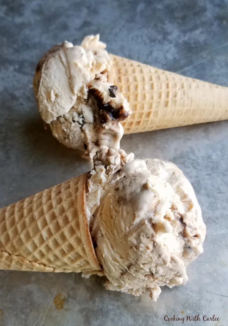 two ice cream cones with a large scoop of ice cream on each.