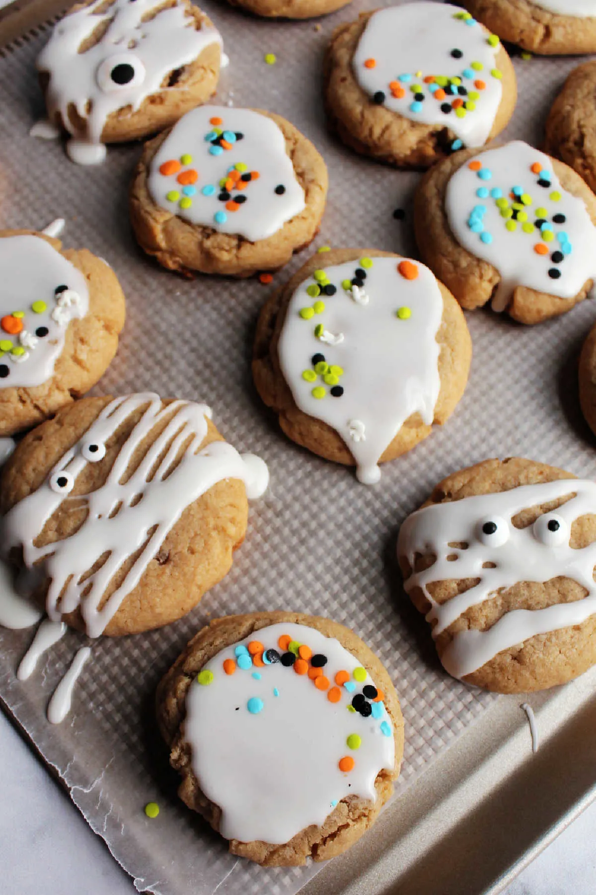 Tray of maple cinnamon cookies with white icing glaze and sprinkles on top.