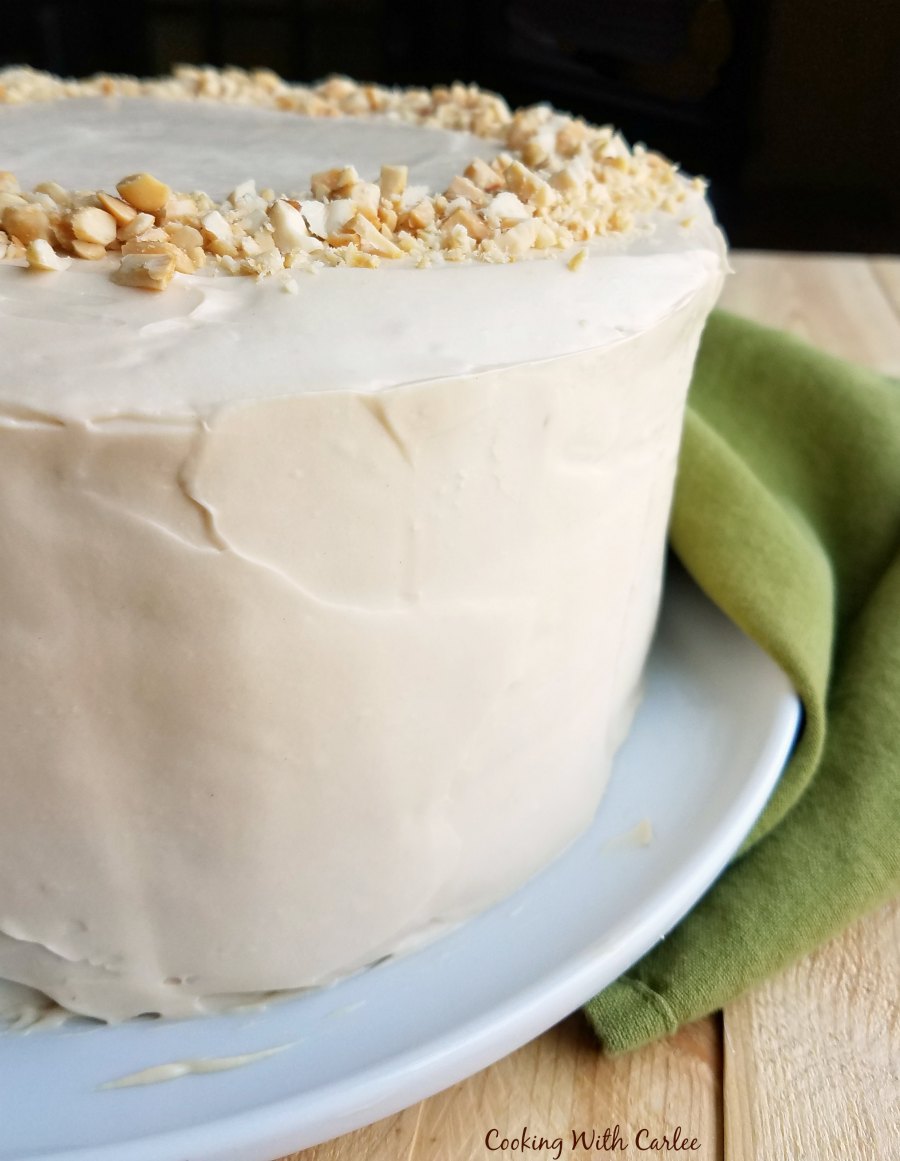 Close up of round layered applesauce cake with smooth caramel frosting.