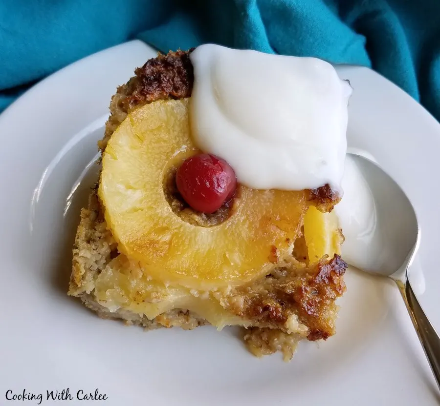 Serving of pineapple baked oatmeal with ring of pineapple and a cherry on top to look like pineapple upside down cake.