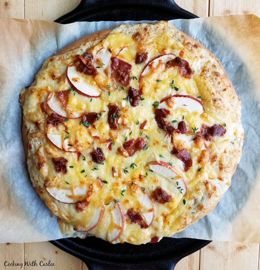 whole apple and bacon pizza with golden brown cheese.